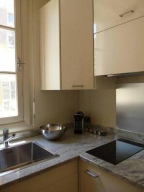 A kitchen with two sinks, a stove, and cabinets. - Chic studio with terrace and beautiful view of the port, 100m from the beach, parking available (Nice)
