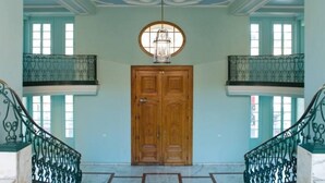 A grand hallway with a wooden double door, a chandelier, and a marble floor. - Chic studio with terrace and beautiful view of the port, 100m from the beach, parking available (Nice)