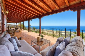 A covered outdoor seating area with a view of the ocean. - Beautiful Holiday Home With Pool (Adeje)