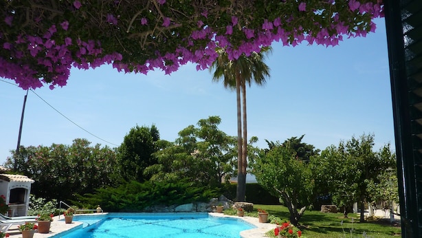 A swimming pool surrounded by lush greenery and flowering plants. - Las Rosas – A Peaceful Mallorcan Retreat with Spectacular Mountain Views (Pollenca)