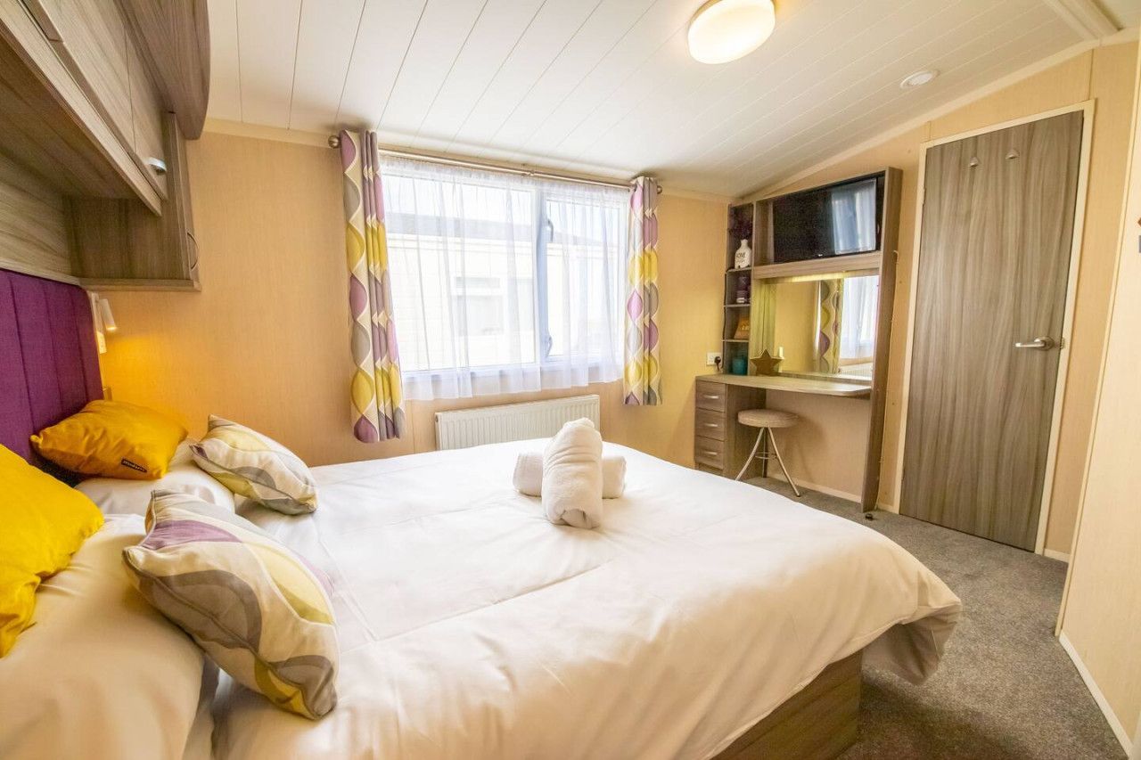 Ein Hotelzimmer mit Bett, Schreibtisch, Fernseher und Kleiderschrank.