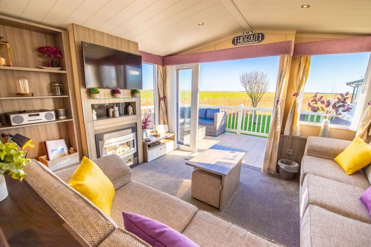 Un salon confortable avec une télévision, un canapé et une vue sur la campagne.