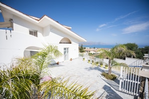 A white building with a tiled patio and potted plants. - splendid villa Corallo 4 ° - 5 °, Relax sea view; OFFER  (Alcamo)