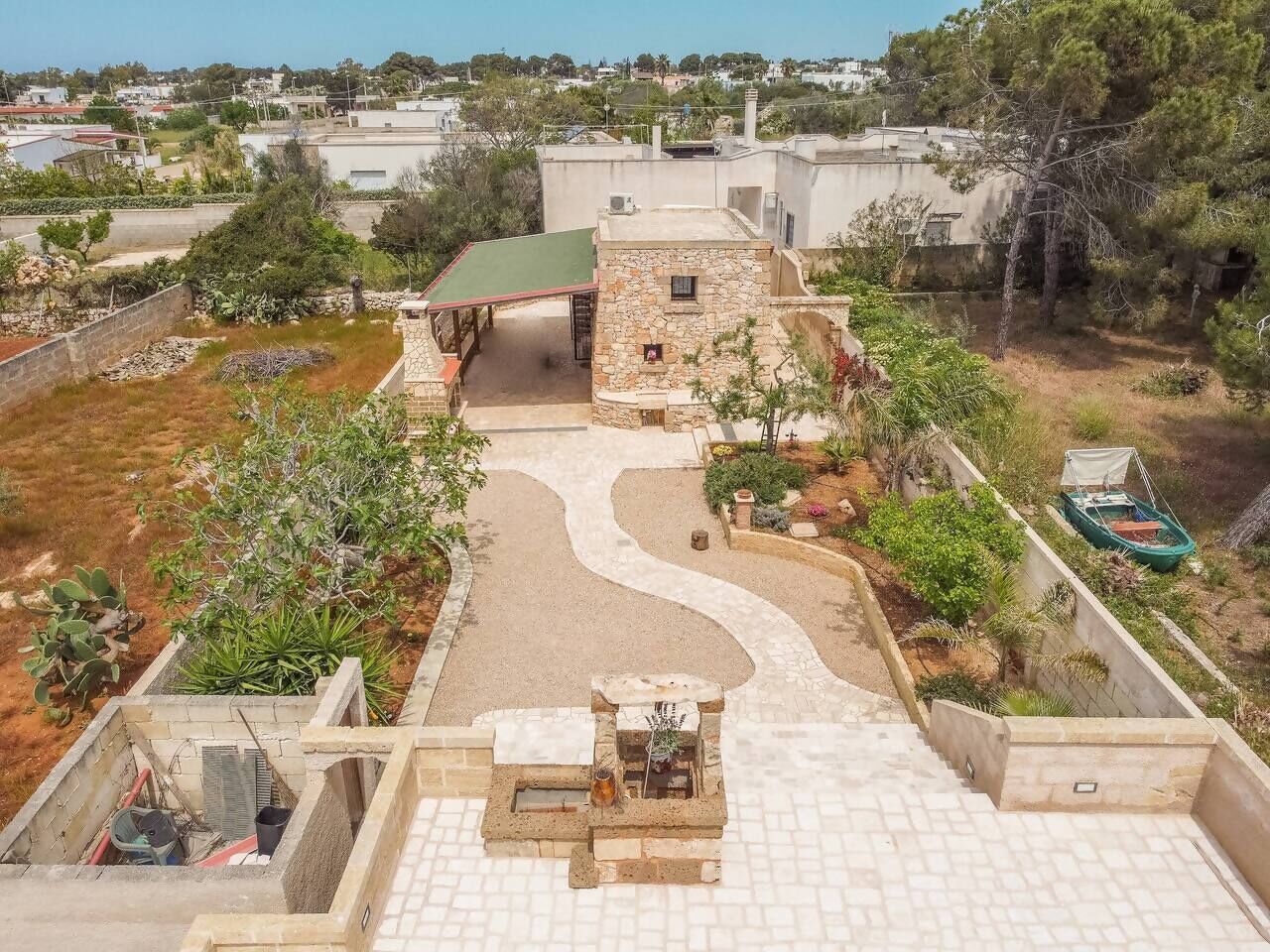 Una terrazza panoramica con una struttura in pietra, un percorso curvo e un piccolo angolo relax.