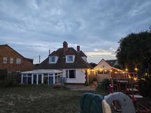 Ein Wohngebiet mit Häusern, einem Wintergarten und einer Terrasse mit Lichterketten.