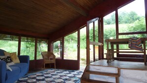 Um quarto aconchegante com um sofá azul, um banco de madeira e um colcha no chão.