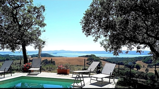 A poolside area with lounge chairs and a view of the sea. - House / Villa - BOLSENA (Bagnoregio)