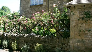 A stone house with a window and a stone wall.