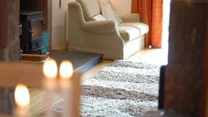 A cozy living room with a sofa, a fireplace, and a rug. - Spacious Riverside Cottage Perfect For Families, groups,pets. ** NEW HOT TUB** (Glasgow)