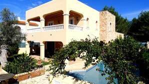 A two-story building with a pool, outdoor seating, and a stone tower. - Ideal house to enjoy with your loved ones. (Santa Gertrudis de Fruitera)