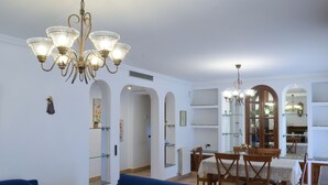 A spacious living area with a blue sofa, a dining table with chairs, and a chandelier. - Ideal house to enjoy with your loved ones. (Santa Gertrudis de Fruitera)