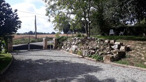 A gravel driveway leading to a gated entrance with a stone wall and a metal gate. - LARGE 4 BEDROOM FARMHOUSE  lots of charm, fully renovated 8+ (Bréhan)