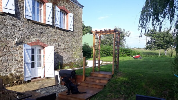 A stone building with a wooden deck, a barbecue grill, and outdoor seating. - LARGE 4 BEDROOM FARMHOUSE  lots of charm, fully renovated 8+ (Bréhan)