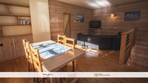 Un interior de madera acogedor con una mesa de comedor, sillas, un sofá y un televisor.