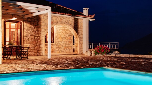 A stone building with a pool, outdoor seating, and a view of the night sky. - Liladi Stone-Built Villa With Exclusive Pool. (Fiskardo)