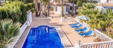 A pool area with a clear view of the surrounding buildings, palm trees, and a satellite dish.