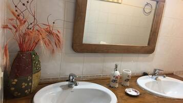 Un baño con dos lavamanos, un espejo y detalles decorativos.