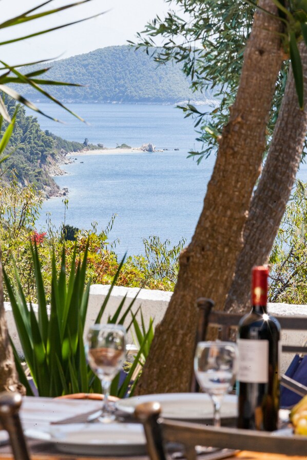 Ein Tisch draußen mit Blick auf das Meer und die Hügel.