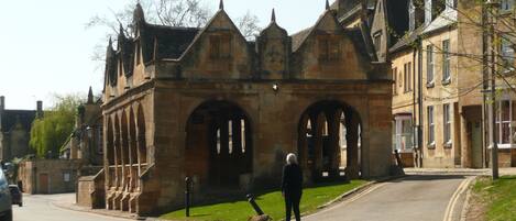 Un bâtiment historique en pierre, doté d’arches au niveau des fenêtres et d’un toit à forte pente.