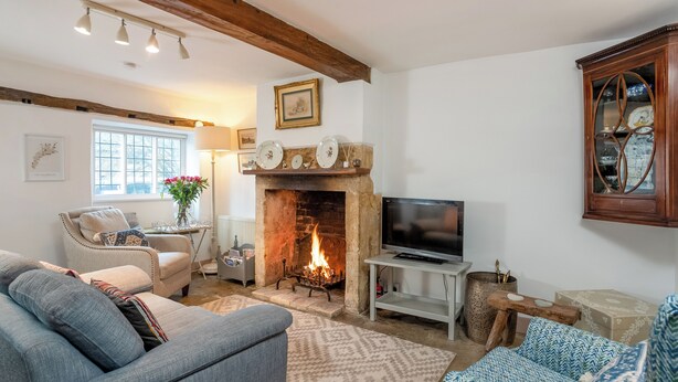 A cozy living room with a fireplace, a television, and comfortable seating. - Wonderful Grade II Cotswold Stone Cottage in Perfect Location (Chipping Campden)