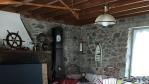 A cozy living room with a red leather sofa, a wooden coffee table, a stone wall, and a foosball table.