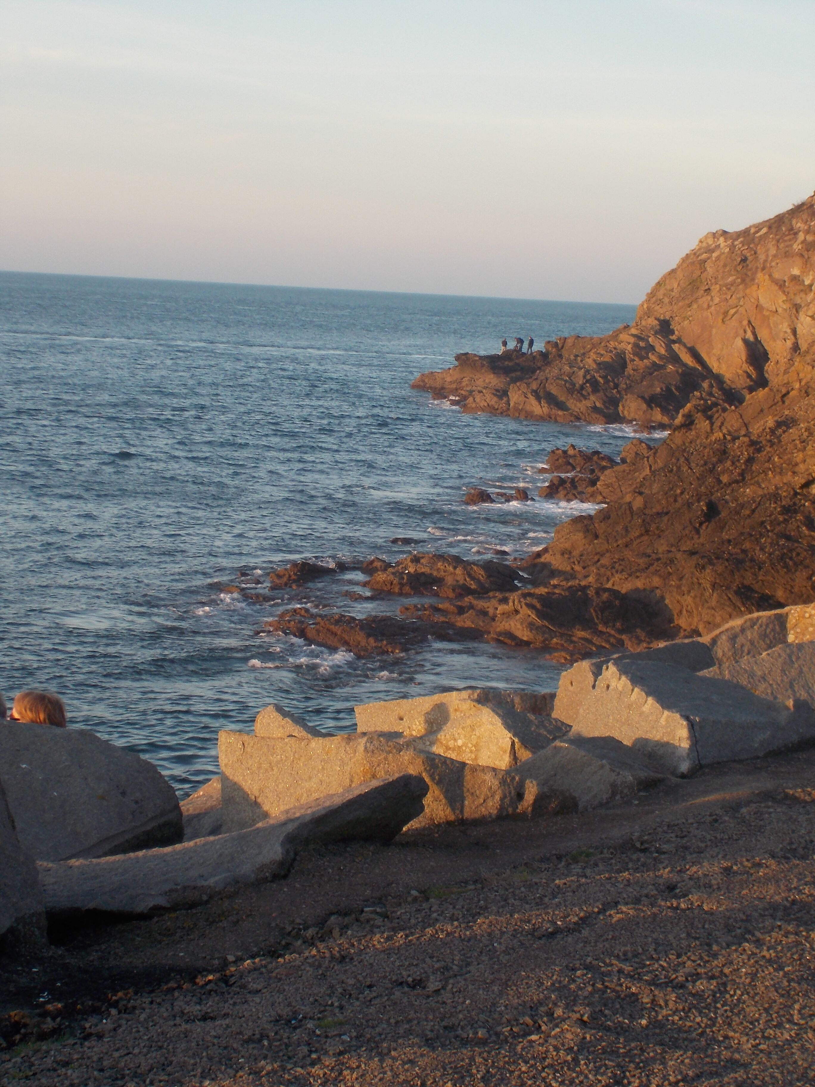 A rocky coastline with waves crashing against the shore.