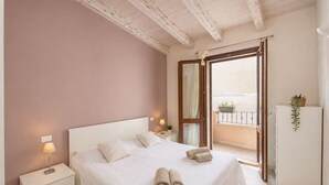 A bedroom with a bed, bedside tables, a wardrobe, a balcony with a view, and a door leading outside. - Brigata House-Luxury 2 bed apartment with sea views, close to sea and shops,wifi (Castelsardo)