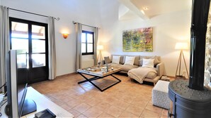 Ein geräumiges Wohnzimmer mit Sofa, Couchtisch und Kamin.