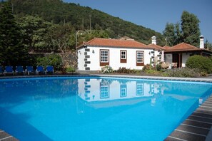 Ein Schwimmbad mit einem weißen Gebäude und braunen Verzierungen im Hintergrund.