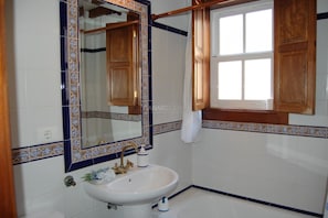 A bathroom with a white sink, a mirror, and wooden cabinets.