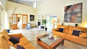 A spacious living area with a large sofa, a coffee table, and a painting on the wall. - Country house with private pool & Tennis Court  - GREAT for families - Free Wifi (Bunyola)