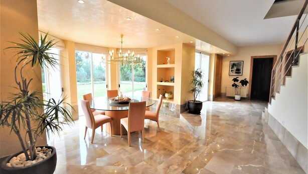 A spacious dining area with a round table and chairs, a chandelier, and potted plants. - Country house with private pool & Tennis Court  - GREAT for families - Free Wifi (Bunyola)