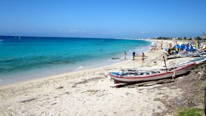 A beach with boats, umbrellas, and people. - Aeriko-Ammos Beachfront Villa with Stunning View and Private Pool (LEFKADA)