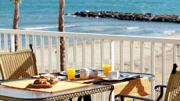 A table with breakfast items and drinks on a balcony overlooking the ocean. - Luxury beachside villa  with private pool, terrace and sea views. (Benicassim)