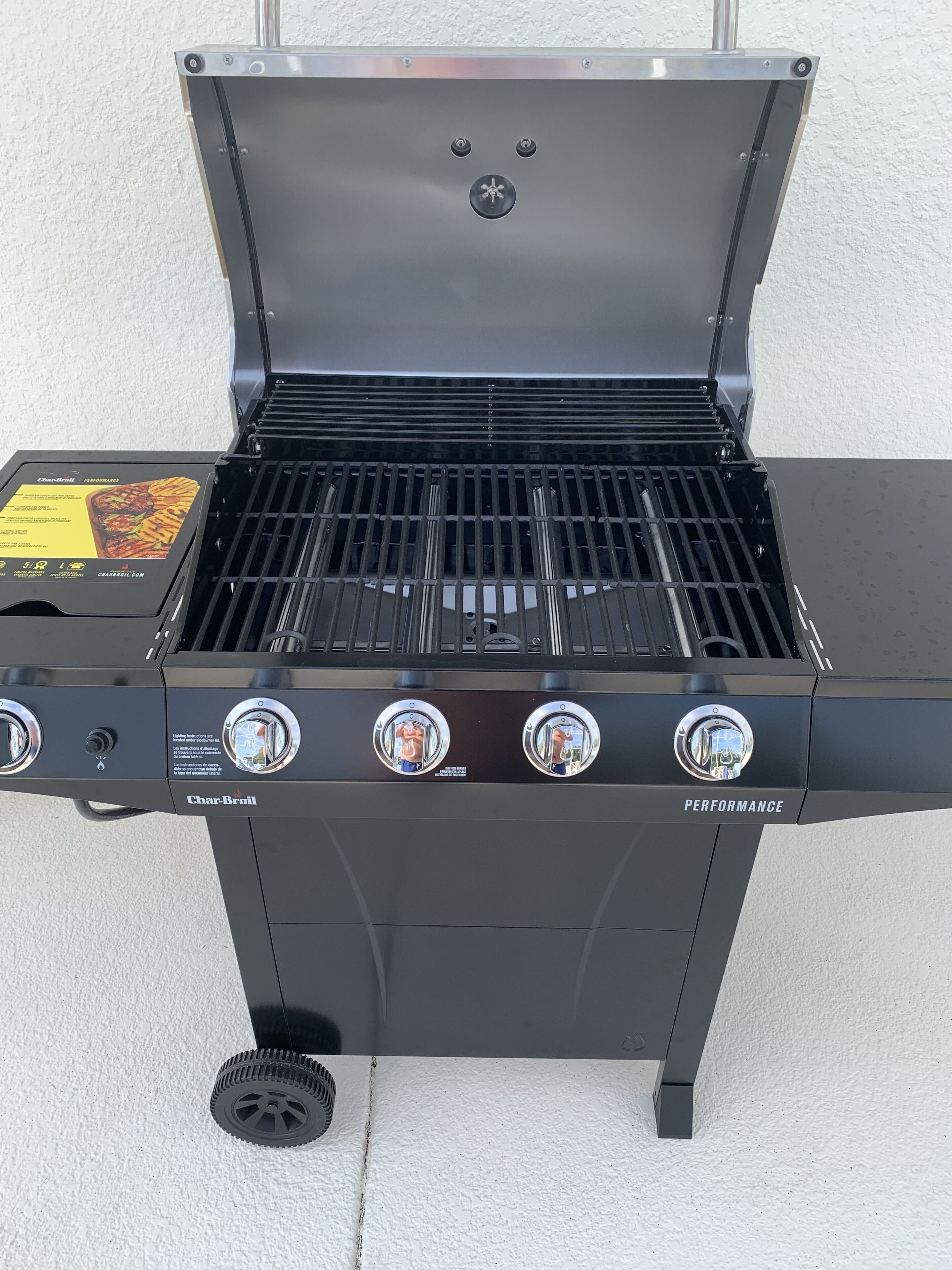A Char-Broil gas grill with four burners, a side burner, and a grease collection tray.