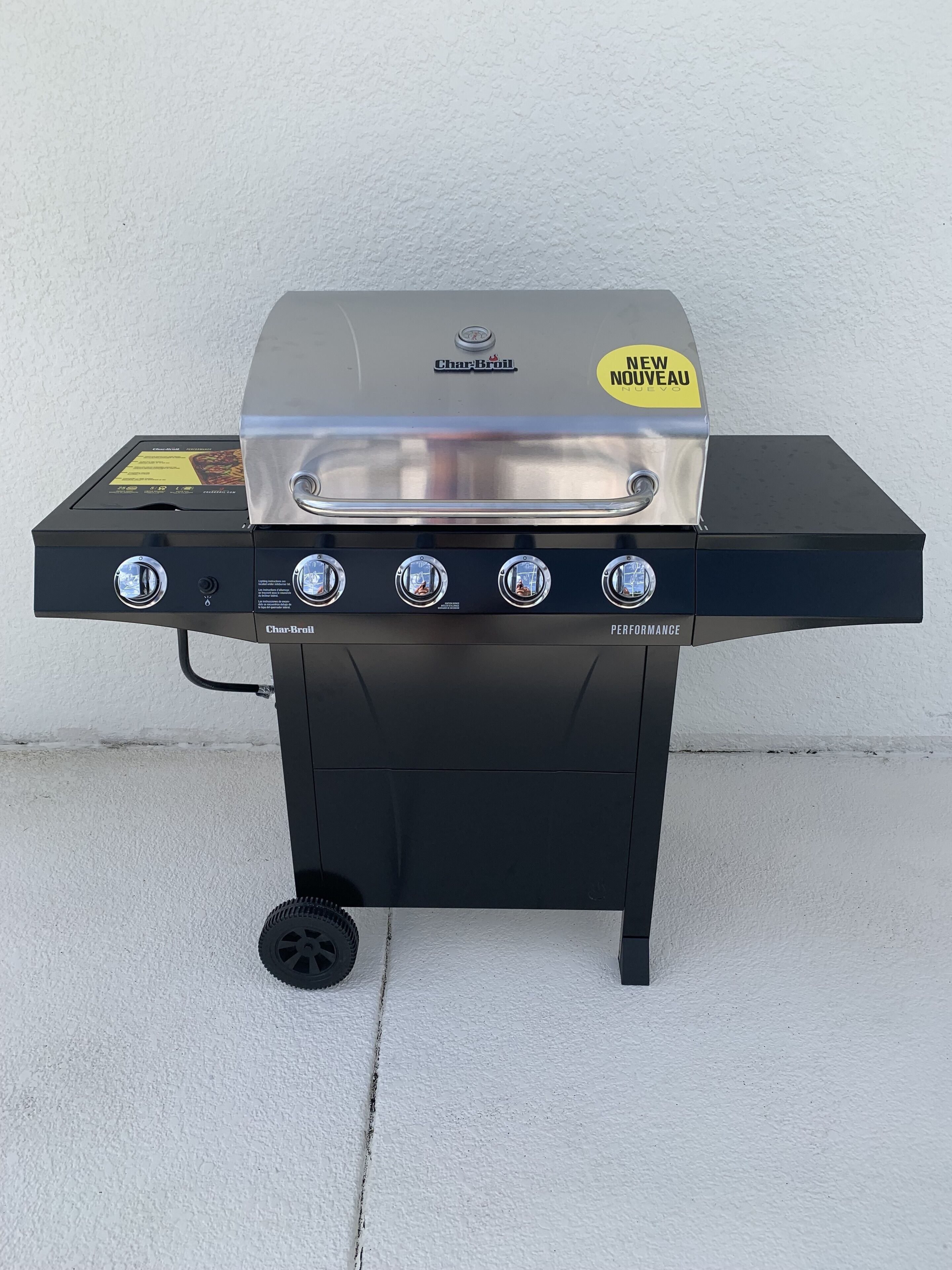 Ein Char-Broil Gasgrill mit vier Brennern, einer digitalen Anzeige und einem 'NEW NOUVEAU'-Aufkleber.