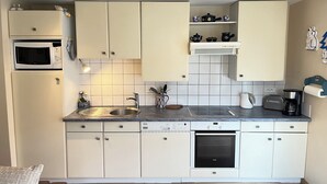 A compact kitchen with white cabinets, a built-in microwave, a coffee maker, and a toaster. - Apartment/ flat - Wettolsheim (Wettolsheim)