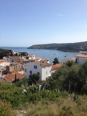 A coastal town with terracotta-roofed buildings, a clear blue sea, and boats anchored in the water. - INCREDIBLE VIEW (cadaques)