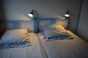 A twin bed with striped bedding and two bedside lamps. - INCREDIBLE VIEW (cadaques)