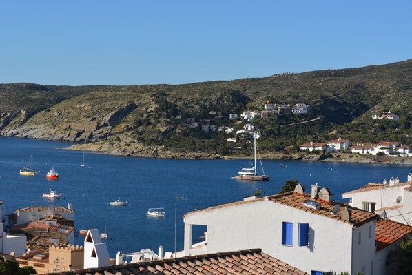 A coastal town with buildings along the waterfront, boats in the water, and a hilly backdrop. - INCREDIBLE VIEW (cadaques)