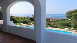 Ein Balkon mit Blick auf einen Pool und das Meer.