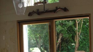 Una habitación con puerta de vidrio corredera que da a un espacio exterior con árboles y un sendero de grava.