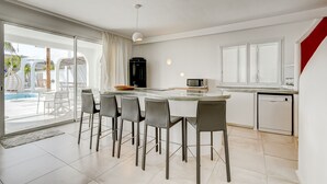 Ett modernt kök med en stor köksö, barstolar, en mikrovågsugn och en diskmaskin.