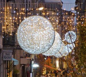 Large spherical decorations with intricate patterns, hanging above a street with buildings and a sign that reads "Yves Rochers". - Well-equipped House At Foot of Medieval Cité with Garage, Wifi & 2 Shower rooms (Carcassonne)