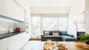 Una cocina moderna con armarios blancos, encimera negra y un comedor con una bandeja de alimentos para el desayuno.