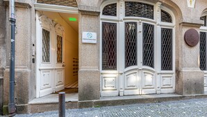 Fachada de edificio de piedra, con un letrero que dice 'Galerias Fashion Flats' y una placa con texto.