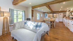 A cozy room with a bed, a dining table, and a kitchen area. - Field Row, Field Dalling, Norfolk (Holt)
