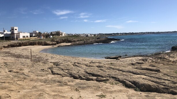A coastal landscape with a sandy beach, rocky shoreline, and buildings in the background. - GALLIPOLI / MARINA DI MANCAVERSA VILLA TUCHESE 4/5 PLACES 100 MT FROM THE SEA (Marina di Mancaversa-giannelli)