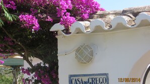 En hvid bygning med skilt, der siger "CASA DO GREGO", og datoangivelse "12/06/2014".