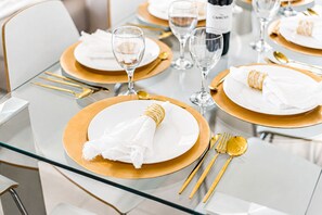 A table set with white plates, gold-rimmed glasses, and gold cutlery. - FABULOUS DUPLEX C9 WITH PRIVATE POOL (Callao Salvaje)